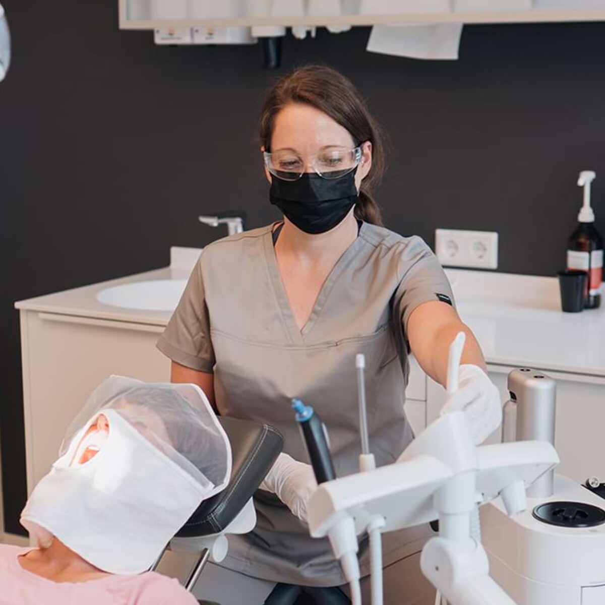 Eine Mitarbeiterin führt eine Prophylaxe an einer Patientin durch.